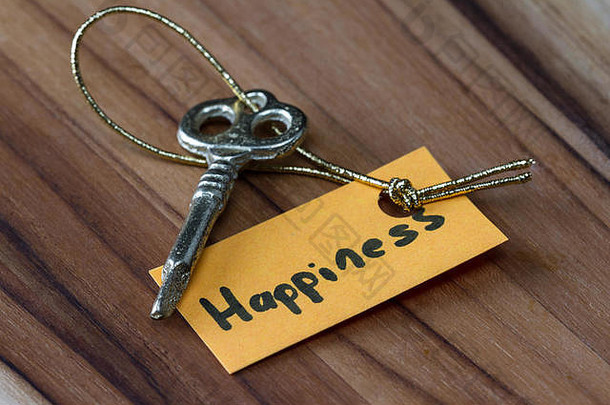 使用一把旧的装饰钥匙和一个用金线系上的手写标签，创造幸福生活的概念