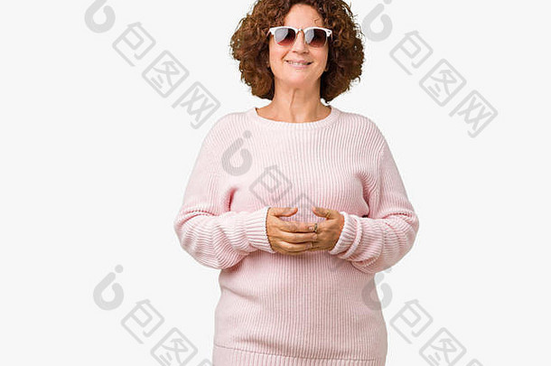 美丽的中年老妇人，穿着粉色毛衣，戴着墨镜，双手合十，面带微笑，轻松<strong>自如</strong>