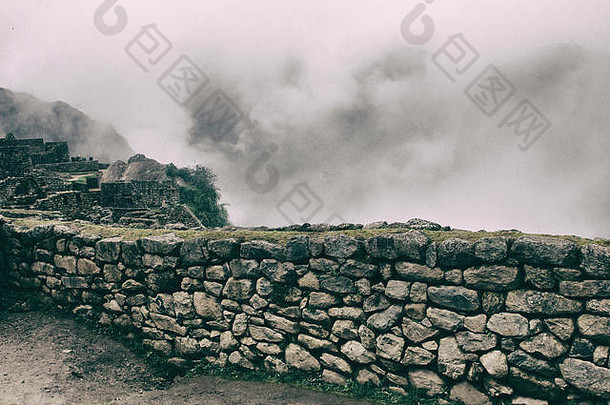 以马丘比丘遗址和云彩为背景的古代安全石墙。没有人。