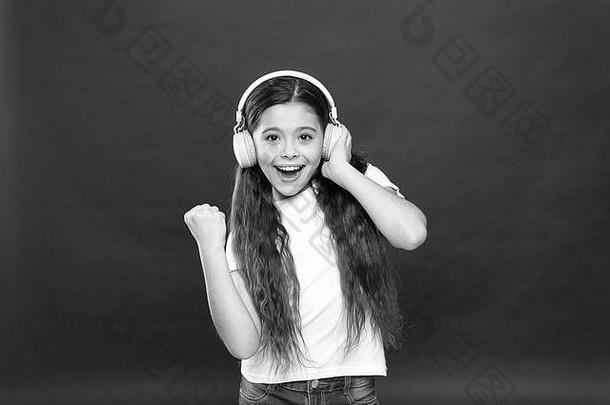 播放列表概念。音乐品味。音乐在青少年的生活中起着重要的作用。音乐对青少年的情感、感知世界有着强大的影响。女孩戴着红色背景的耳机听音乐。