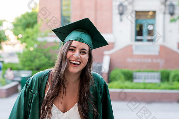 大学<strong>四年级</strong>毕业前，一个漂亮女孩在校园里摆着毕业照。
