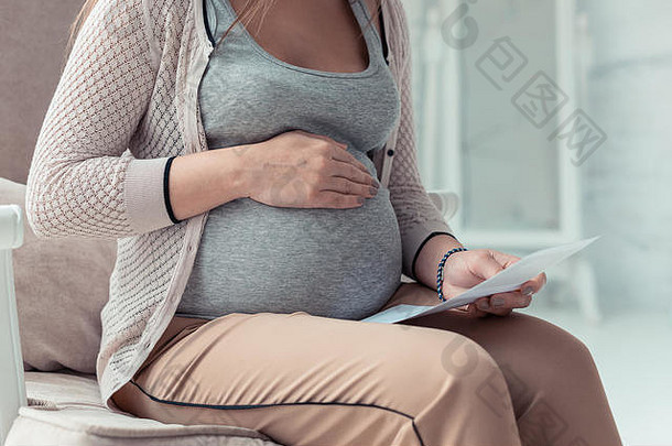 坐在扶手椅上的怀孕照片