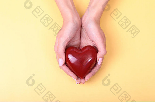 一个女人手里拿着一颗红色的心