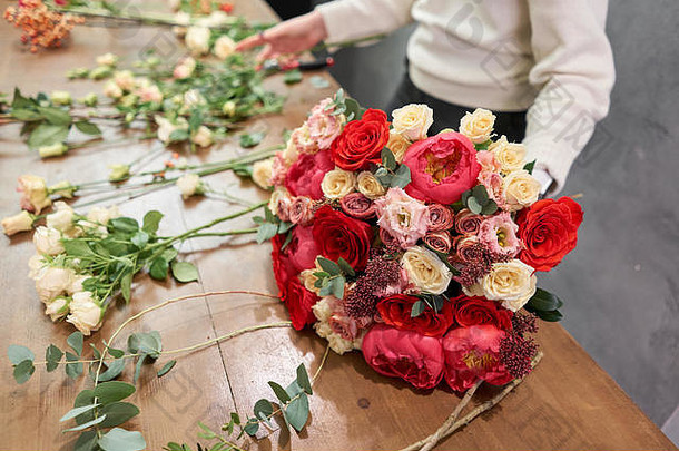 欧洲花店概念。花店女人创造了一束美丽的红色混合花。漂亮的新鲜的一束。教育、<strong>硕士班</strong>和