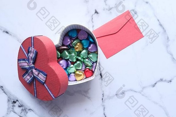 心形礼品盒、糖果和瓷砖背景上的字母