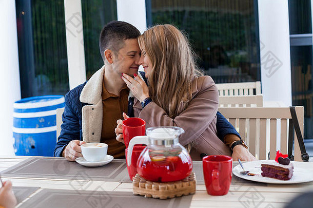街上的餐馆。一个男人和一个女孩喝热咖啡和茶