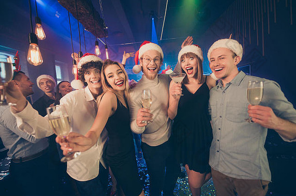 跳舞照片聚会，派对人群朋友持有闪闪发光的酒眼镜newyear节日x-mas情绪穿礼服衬衫裤子圣诞老人帽子