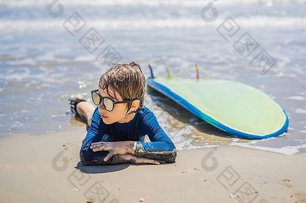 年轻的冲浪者，带着冲浪板在海滩上快乐的小男孩