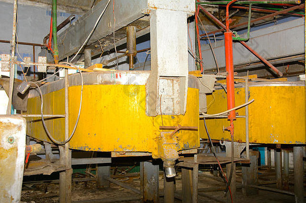 靠墙的一个废弃的、被摧毁的工厂里用来收集牛奶的一个破旧的、生锈的大罐。破坏和故意破坏。乌克兰。