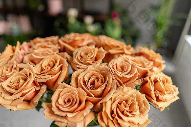 焦糖色，玻璃花瓶里的托菲玫瑰。美丽的玫瑰花目录或网上商店。花店概念。美丽的鲜切花束