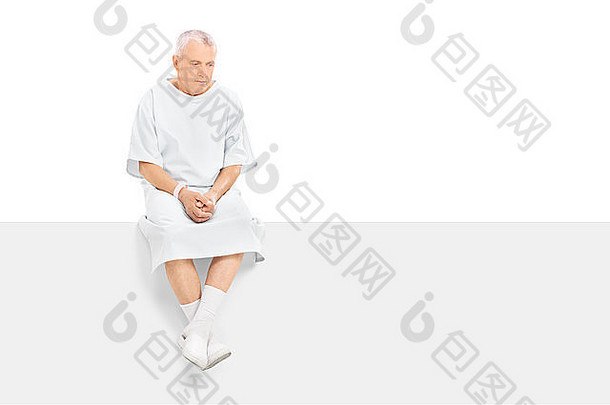 焦虑的成年患者坐在白色背景上隔离的空白面板上