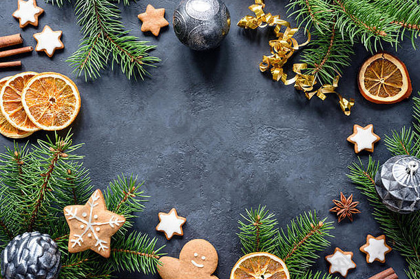 圣诞或新年框架，以冷杉树枝、姜饼<strong>饼干</strong>、香料、干橙色戒指和圣诞玩具为石头背景。拷贝空间