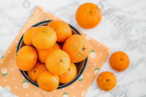 白色大理石搪瓷碗中的成熟多汁柑橘
