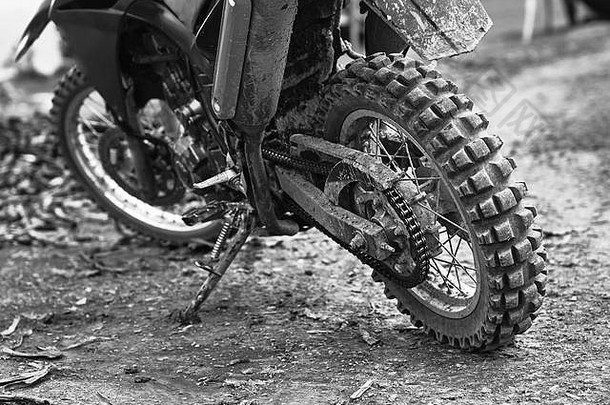 越野山地摩托车或参加摩托车大赛的自行车停放在肮脏的路面上