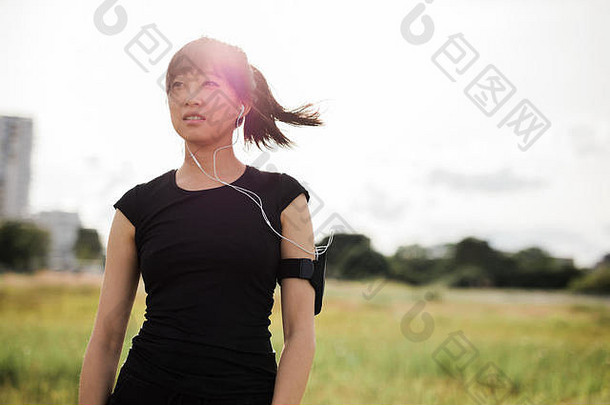 拍摄年轻的女人运动服装站在户外城市公园阳光明媚的一天中国人女跑步者准备好了