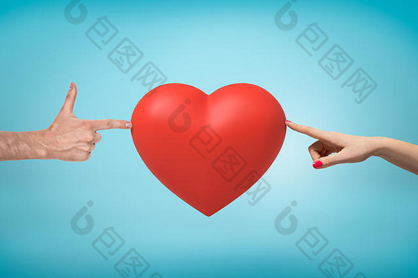 女人的手在右边，男人的手在左手做手指，在蓝色的背景中间触摸着一个红色的情人节大红心。