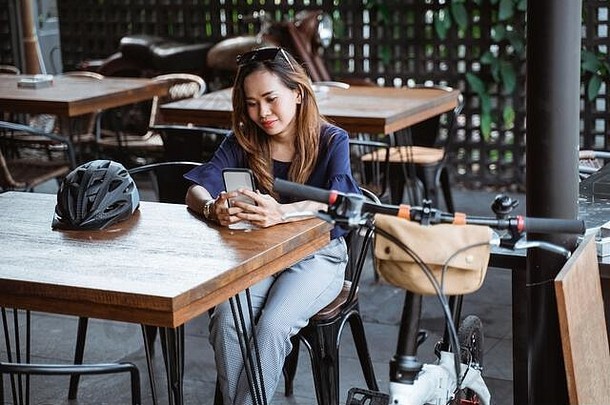有趣的亚洲女人智能手机打破咖啡馆