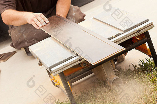 承包商使用圆锯切割新强化木地板翻新。