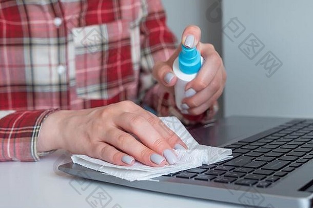 女人手喷涂防腐剂清洁移动PC键盘消毒液湿擦白色表格消毒保护预防做家务