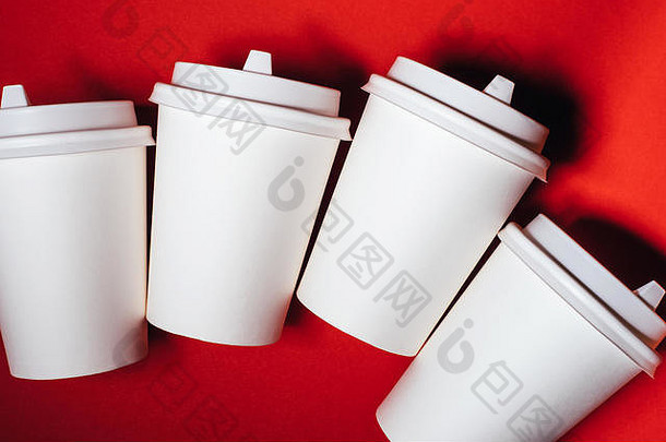 四个红色背景的咖啡或茶纸杯。