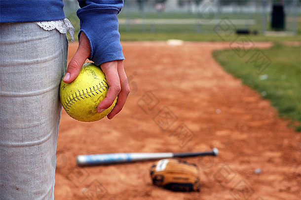 一个女孩在内场<strong>钻石</strong>上拿着一个垒球。