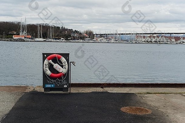 挪威斯塔万格海岸的救生圈，背景是小船