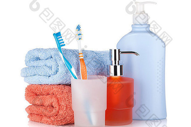 牙刷、洗发水瓶和两条毛巾。在白色背景上隔离