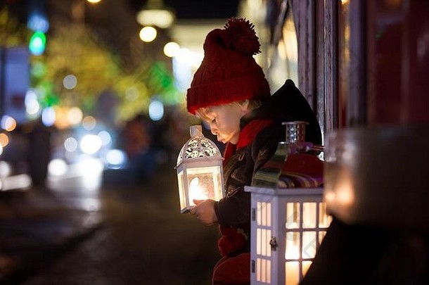 圣诞夜，布拉格，一个可爱的蹒跚学步的小男孩手里拿着灯笼和一只泰迪熊