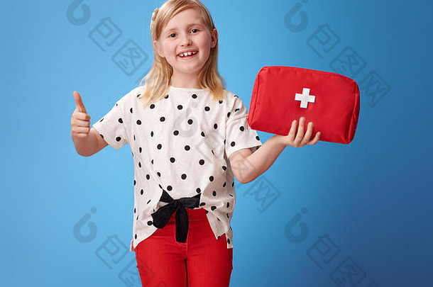 微笑现代孩子红色的裤子显示急救工具包拇指孤立的蓝色的