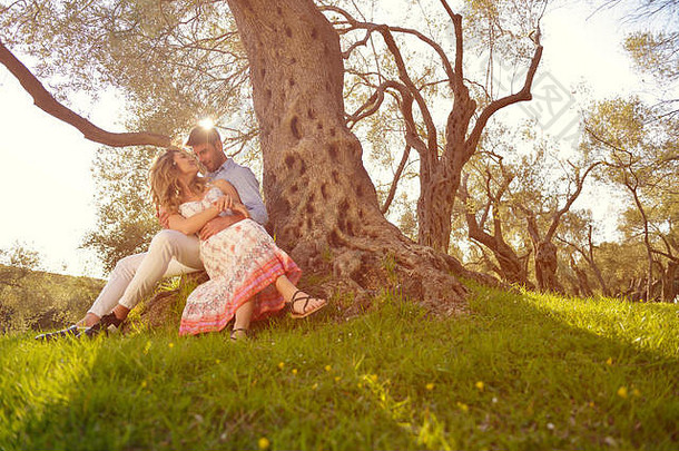 这对夫妇在树下休息。美术风格。橄榄园。