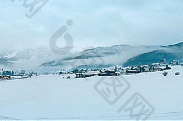 冬天山村朦胧的景观低垂的云奥地利