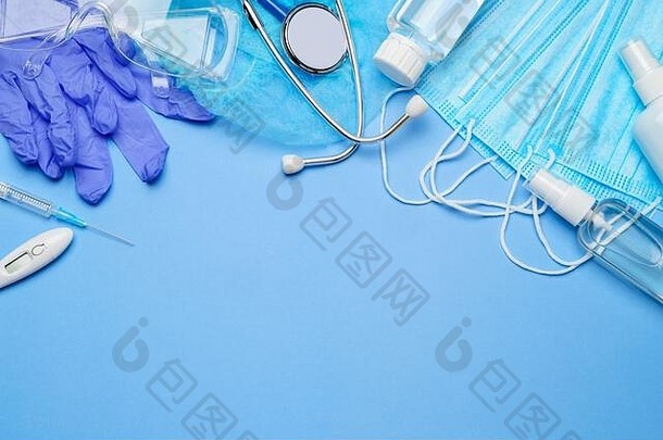 <strong>冠状病毒防护</strong>概念-蓝色背景上的乳胶手套、面罩、洗手液注射器、听诊器和温度计
