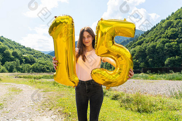十几岁的女孩持有金气球数量