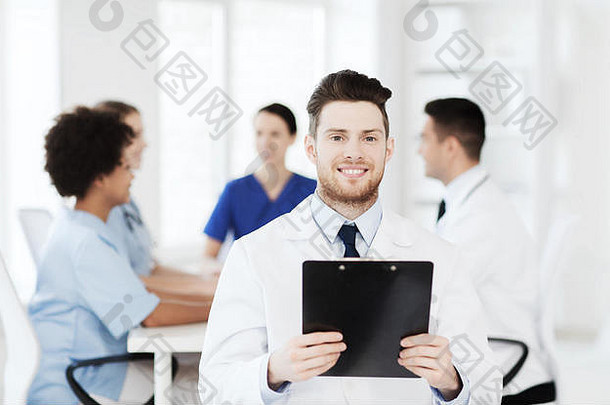 带平板电脑的快乐医生在诊所的团队中