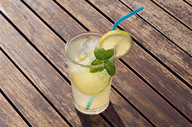 新鲜的柠檬水莫吉托鸡尾酒玻璃稻草木表格