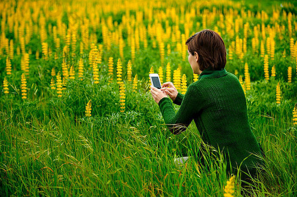 用手机给鲜花拍照的女人