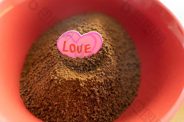 红色碗里的一堆速溶咖啡，上面贴着爱的标签
