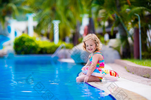 女孩和男孩在热带度假村的游泳池里玩耍。学习游泳的孩子。蹒跚学步的小孩，带着玩具桶和水壶。