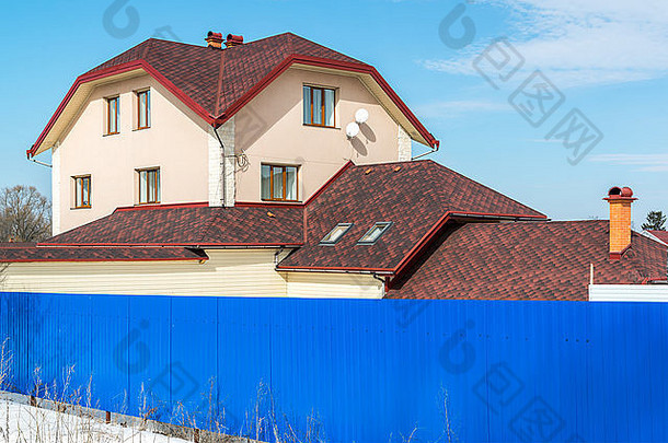 蓝色篱笆后面的标准两层小屋
