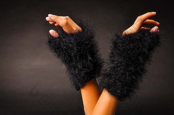 一双手举到空中，戴着黑色马海毛编织的无指保暖手套
