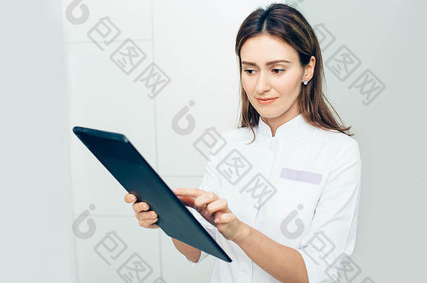 一名女医生在诊所使用数码平板电脑的照片