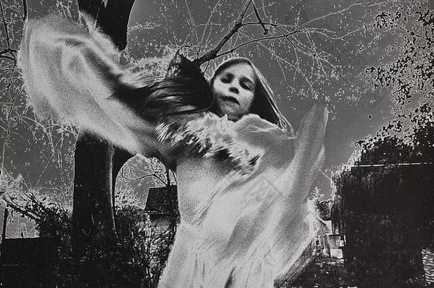 精美的70年代黑白极限摄影，一个穿着白色连衣裙的女孩<strong>旋转</strong>着