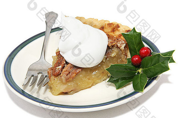 美味的圣诞南美洲山核桃派，用鲜奶油和冬青枝点缀在白色蛋糕上