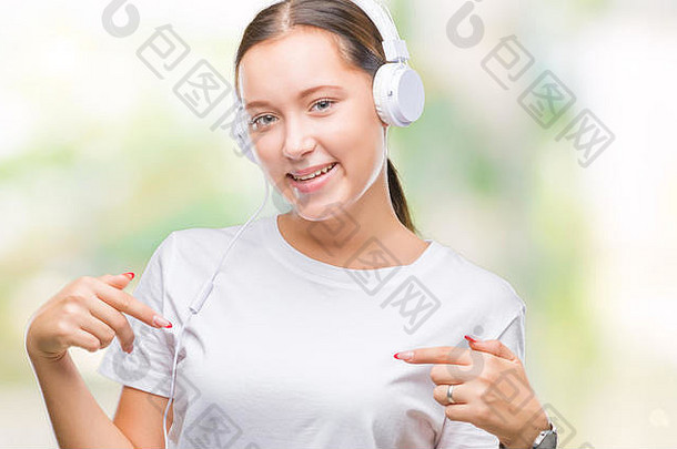 年轻的高加索人女人听音乐穿耳机孤立的背景自信微笑脸指出自己芬格