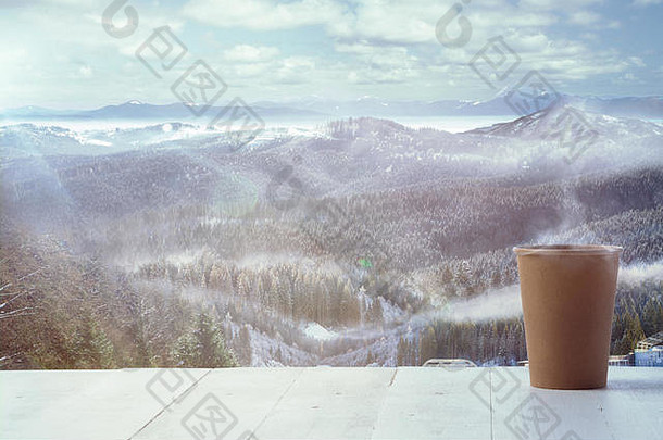 单个茶杯或咖啡杯，背景为山脉景观。一杯热饮，阳光明媚，眼前是晴朗的天空。春暖花开的日子，节假日，旅游，探险的时光。