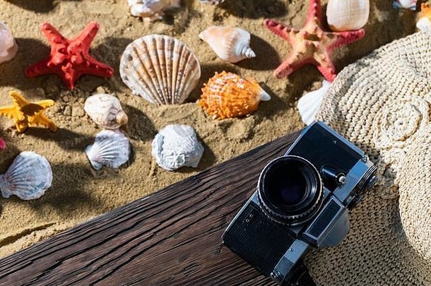 旧照相机。旅游用品放在站台上。海滩的沙滩。