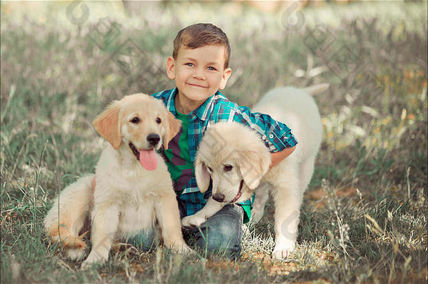 可爱英俊的男孩，蓝眼睛的少年，在户外玩耍，令人惊异的白色粉色拉布拉多猎犬，享受夏日阳光明媚的假期周末，尽情玩耍