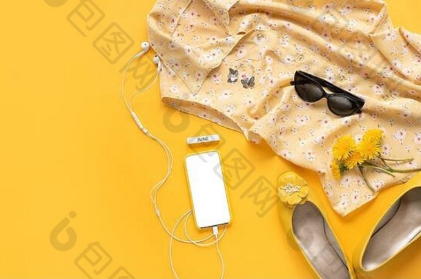 女孩生活方式配饰的特写照片。一个现代女孩的随机对象的静物画。花衬衫，耳机，电话，耳环