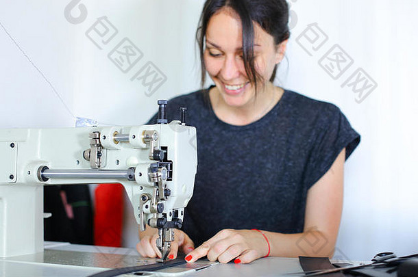 女裁缝用缝纫机缝制皮带。