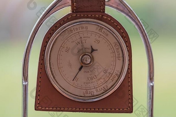 一个古老的气压计的特写镜头，由一个旧马镫制成，显示高压和晴朗的天气。
